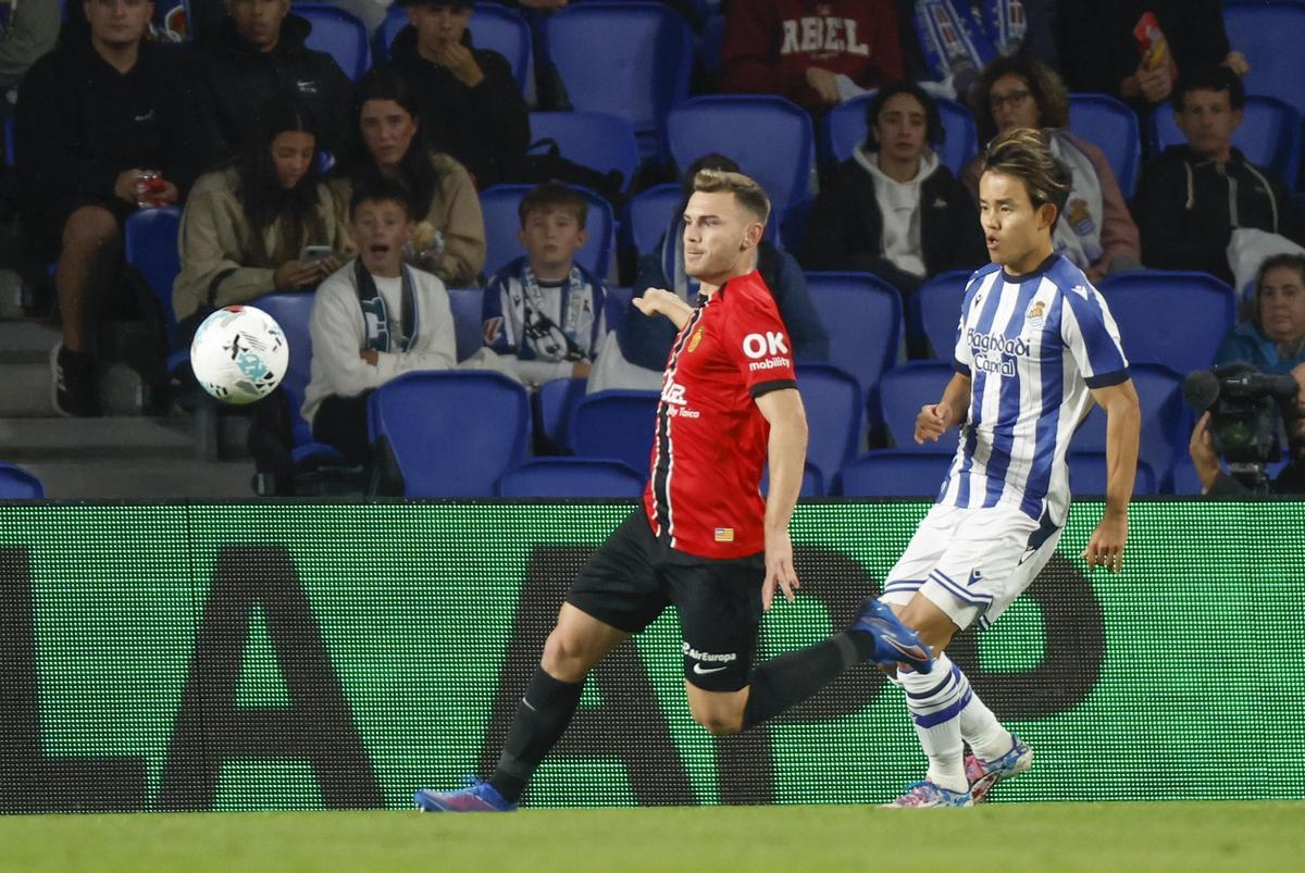 Kubo envía un balón a un jugador de la Real bajo la presión de Toni Lato.