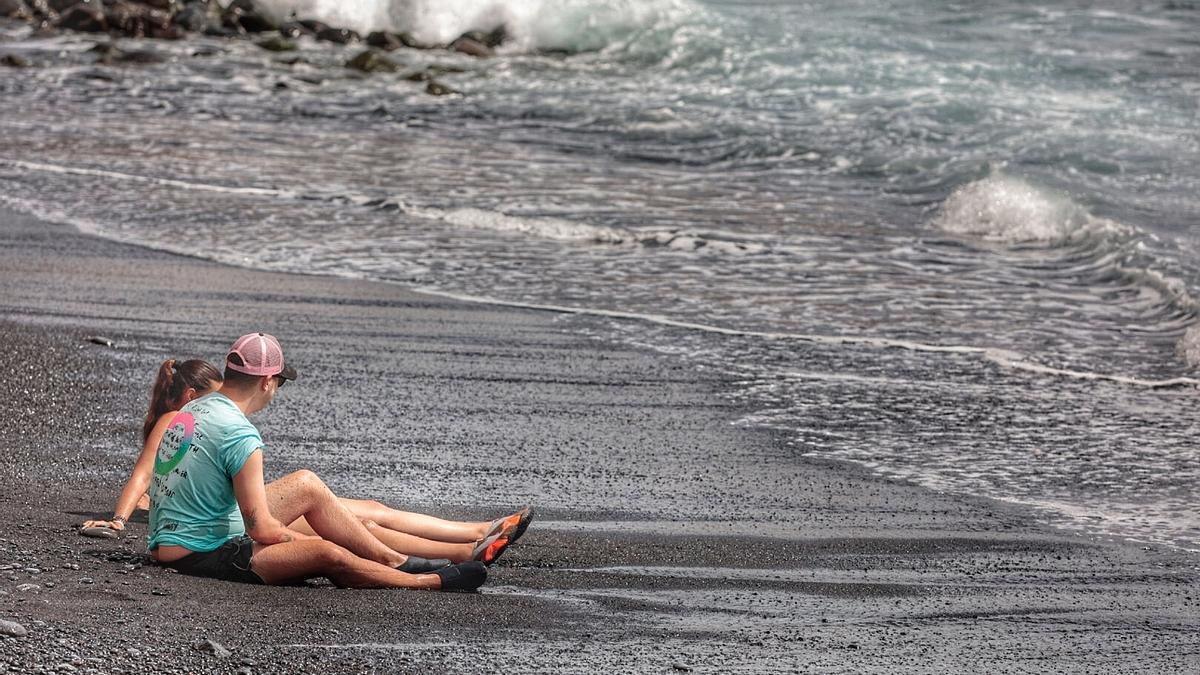 Dos personas se refrescan en la playa en un día de calor en Tenerife.