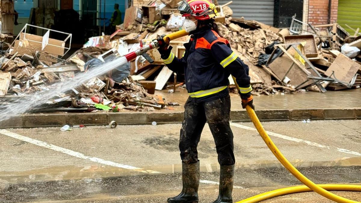 Una voluntaria de Protección Civil de Xàbia realiza labores de limpieza en Catarroja