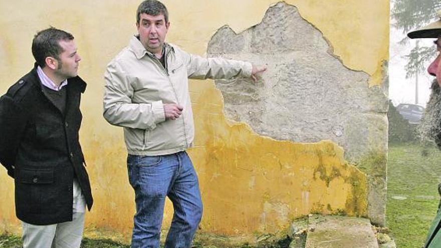 El alcalde cangués y el secretario de la asociación cultural observando los daños del templo.