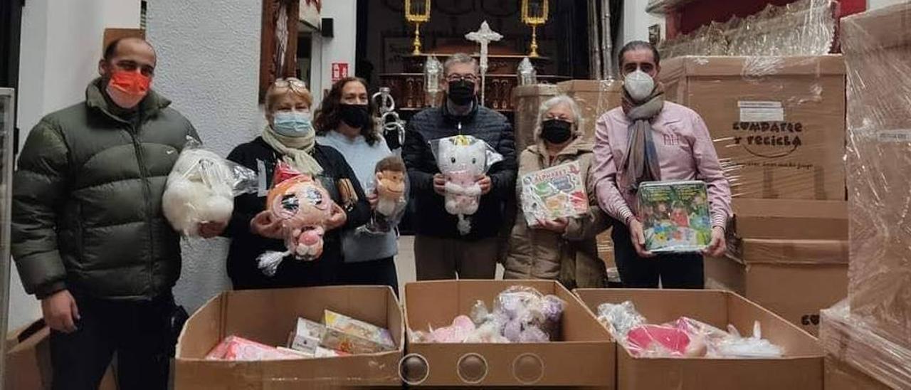 Miembros de la hermandad de la Santa Cena con los juguetes recogidos