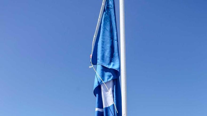 A la izquierda, izado de la bandera azul en el Puerto Deportivo.