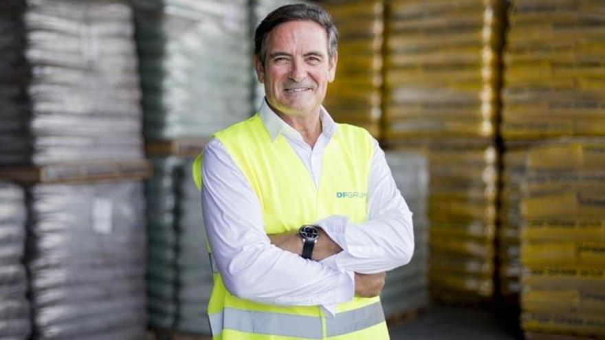 Carlos Delso, en su almacén de abonos en Sagunto (Valencia). Abajo, junto a uno de los sacos salidos de la envasadora.