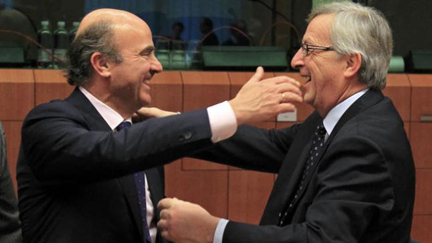 Guindos y Juncker se saludan efusivamente.