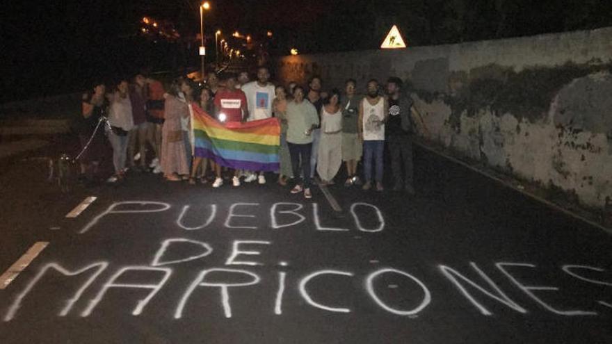 Integrantes del colectivo Violetas LGTBi posan ante una de las pintadas que apareció ayer en Tazacorte.