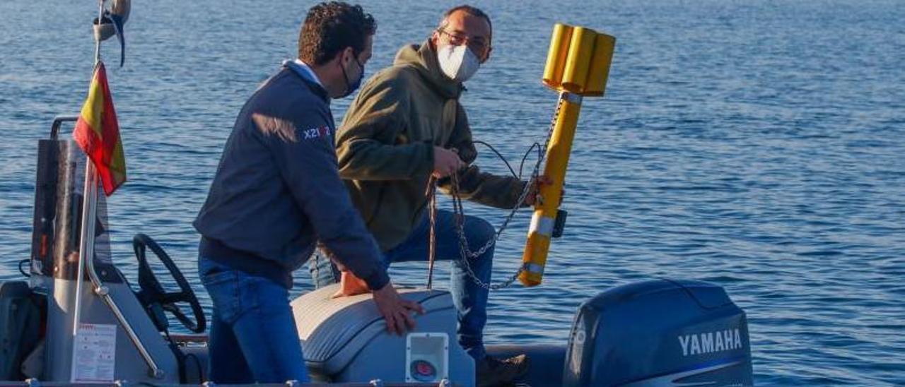 El arqueólogo Cristóbal Nodar muestra al delegado de la Xunta el sónar de barrido lateral para analizar la topografía del fondo.