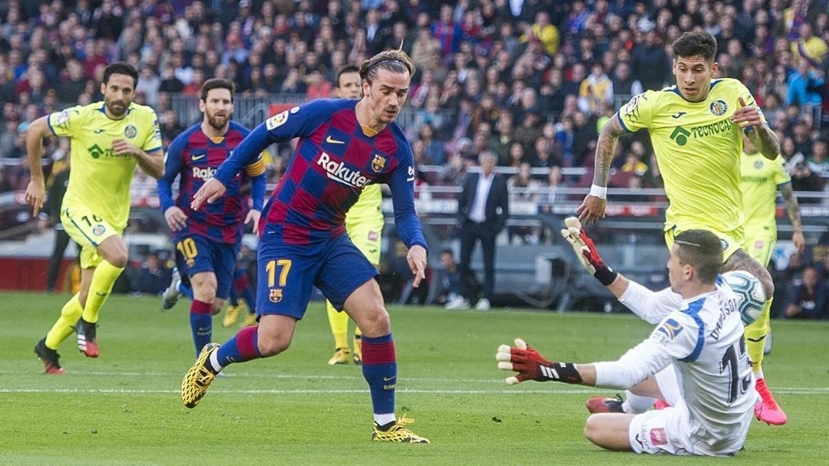 Griezmann cruza el balón con su pie izquierdo y supera al portero Soria en el primer gol azulgrana durante el partido de liga entre el FC Barcelona y el Getafe.