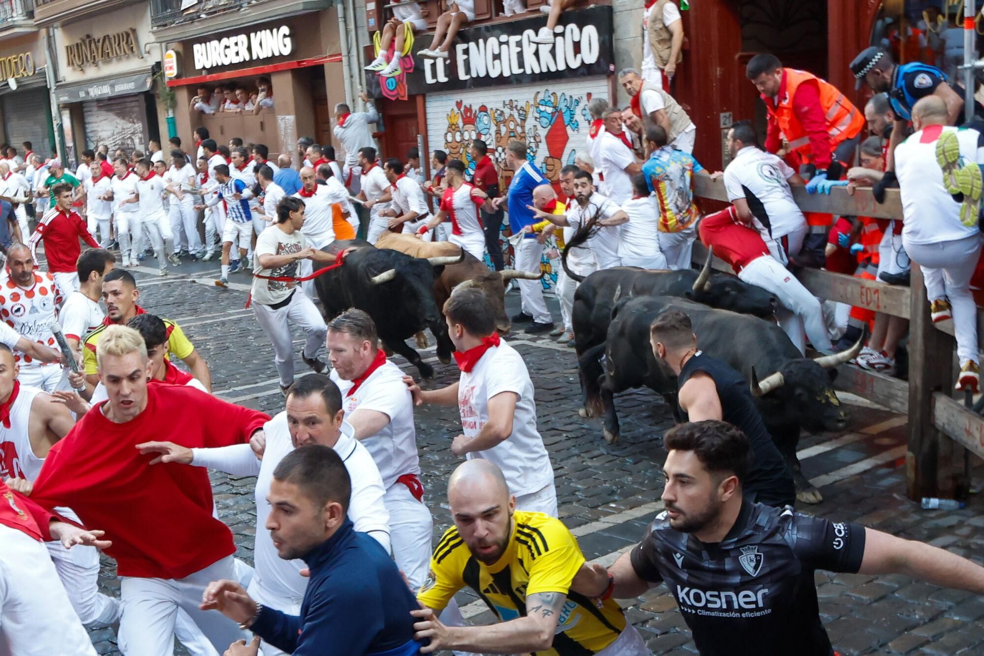 PAMPLONA, 13/07/2025.- Los mozos son perseguidos por toros de la ganadería gaditana de La Palmosilla s durante el séptimo encierro de los Sanfermines 2025 este domingo en Pamplona. EFE/Jesús Diges