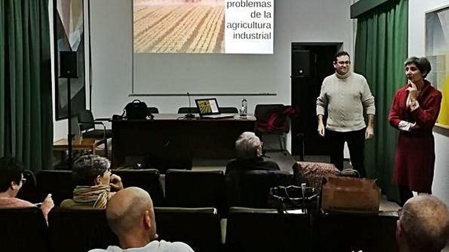 Ester Castro y José Antonio Alonso, de pie, presentan la conferencia sobre agricultura industrial.