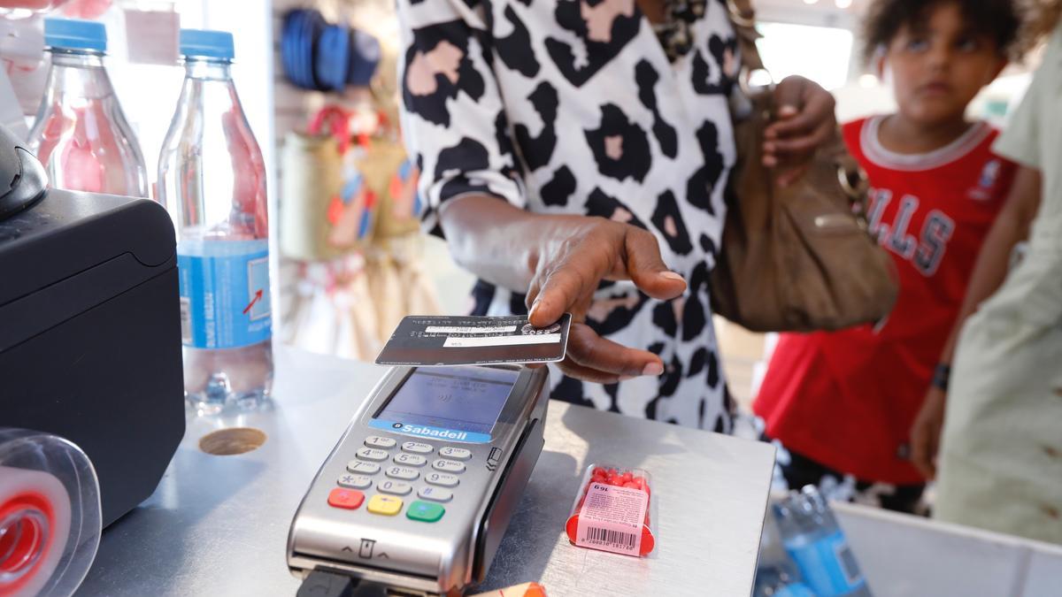 Una cienta paga con una tarjeta de crédito en un comercio.