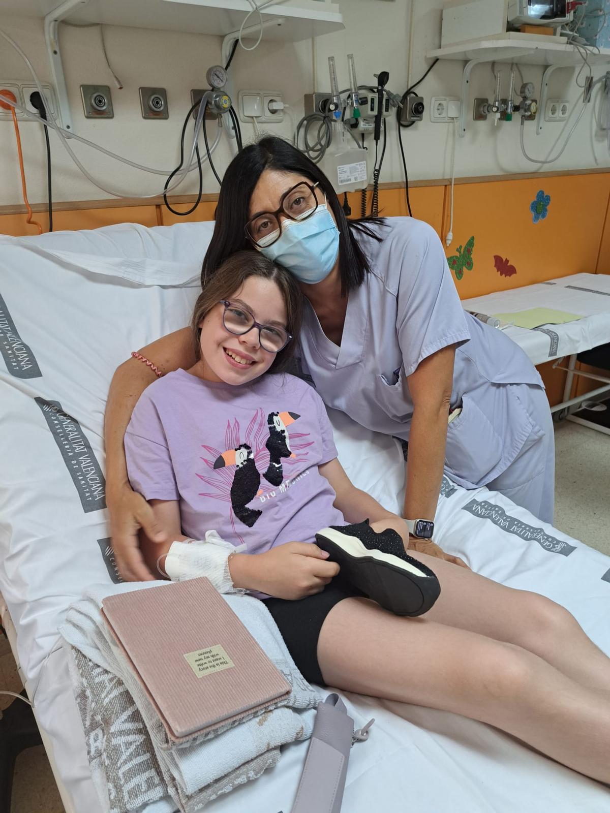 Una de las menores que reciben tratamiento en el Hospital general de Elche posa con sus nuevas zapatillas.