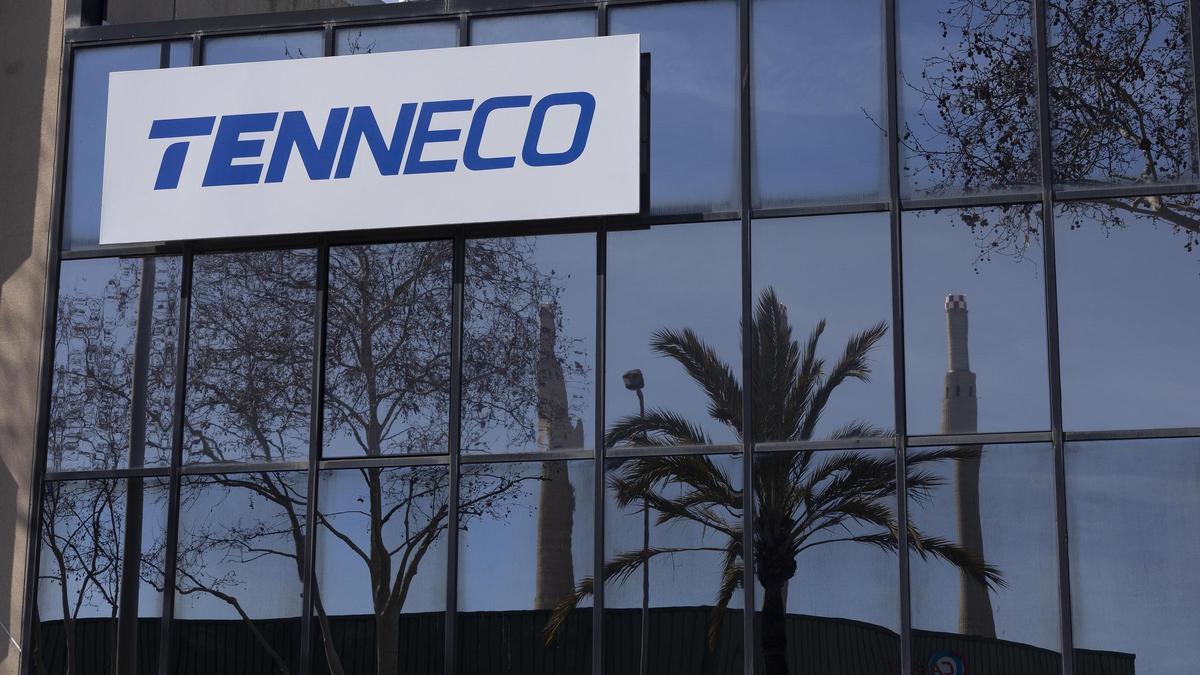 La fachada de la empresa Tenneco, con las Tres Xemeneies reflejadas en el cristal, en Badalona.
