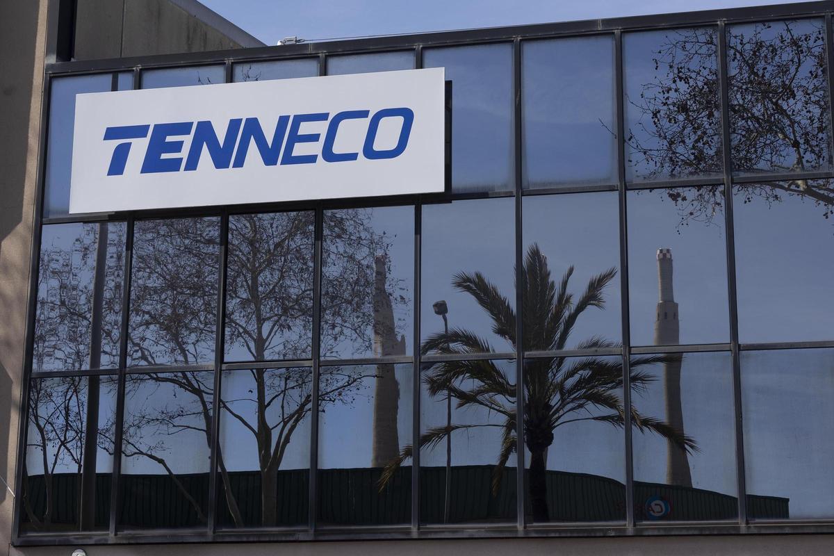 La fachada de la empresa Tenneco, con las Tres Xemeneies reflejadas en el cristal, en Badalona.
