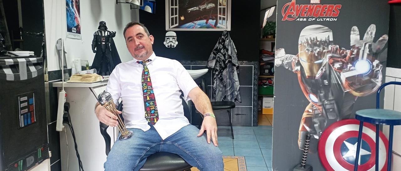 Antonio, esta semana, en su peluquería de Churriana, con figuras de Star Wars y Marvel, y una réplica de la última Copa del Rey de Unicaja.