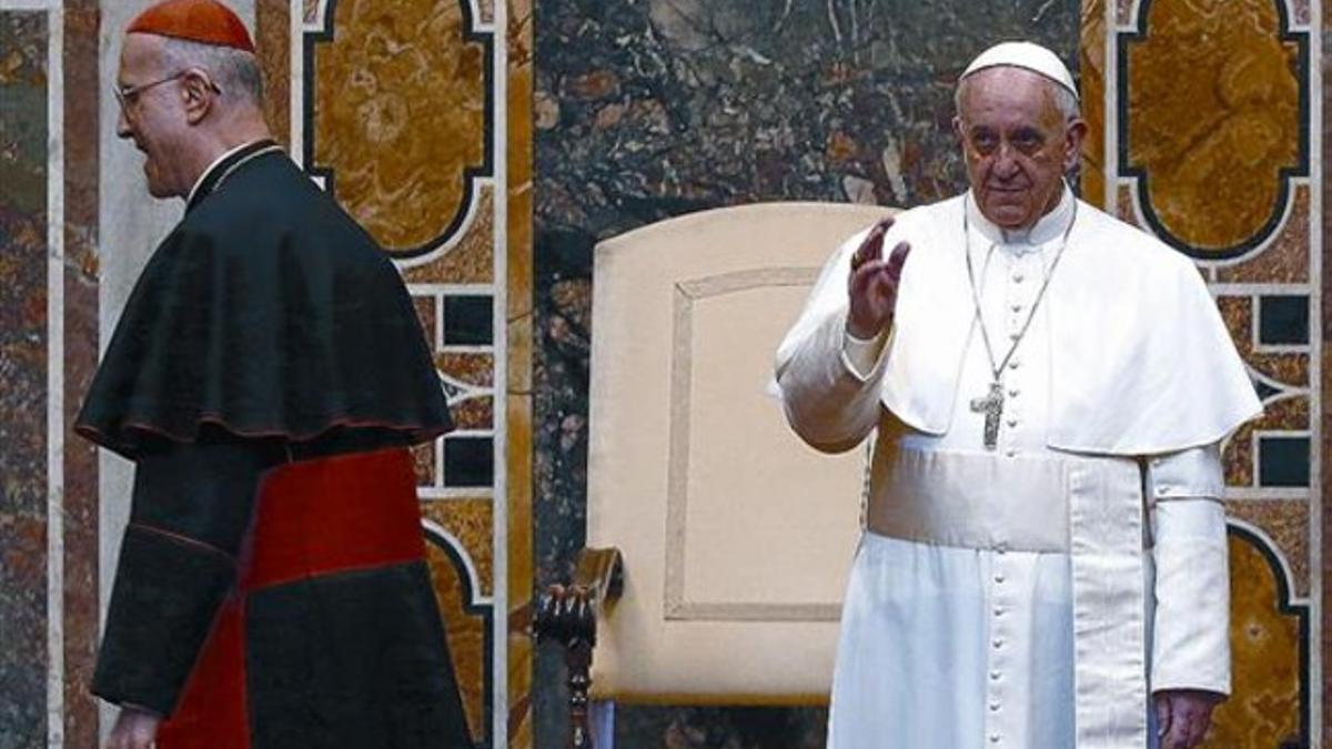 Bendición 8 El cardenal Tarsicio Bertone pasa junto al papa Francisco, ayer, en una audiencia en el Vaticano.