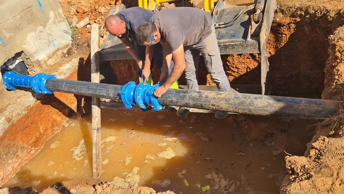 Dos operarios trabajan en las tuberías de la cabecera del Pou del Carraixet, en Xàtiva.