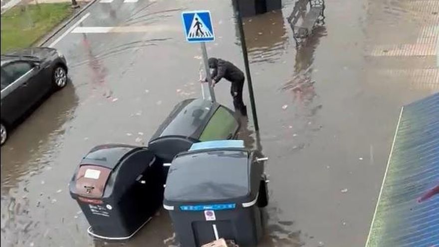 Un vecino trata de desatascar una alcantarilla este miércoles en María Auxiliadora en Badajoz.