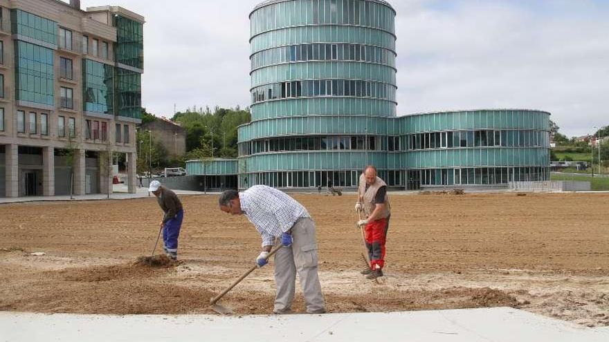Trabajadores del concello alisan la superficie de la plaza, todavía en tierra.