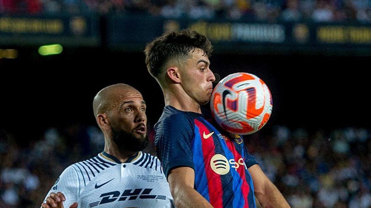 Pedri controla un balón en presencia de Alves.