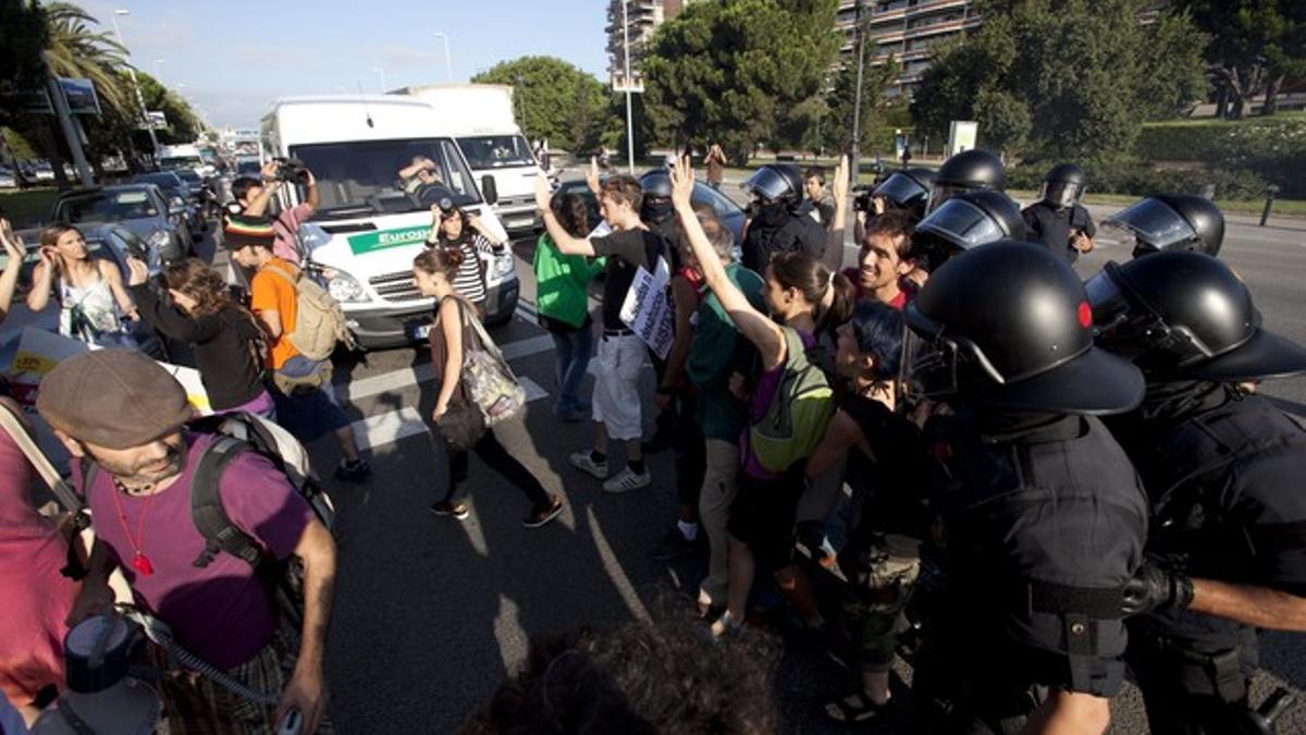 Varios 'mossos' desalojan al grupo de indignados que han intentado cortar la Diagonal, este jueves.