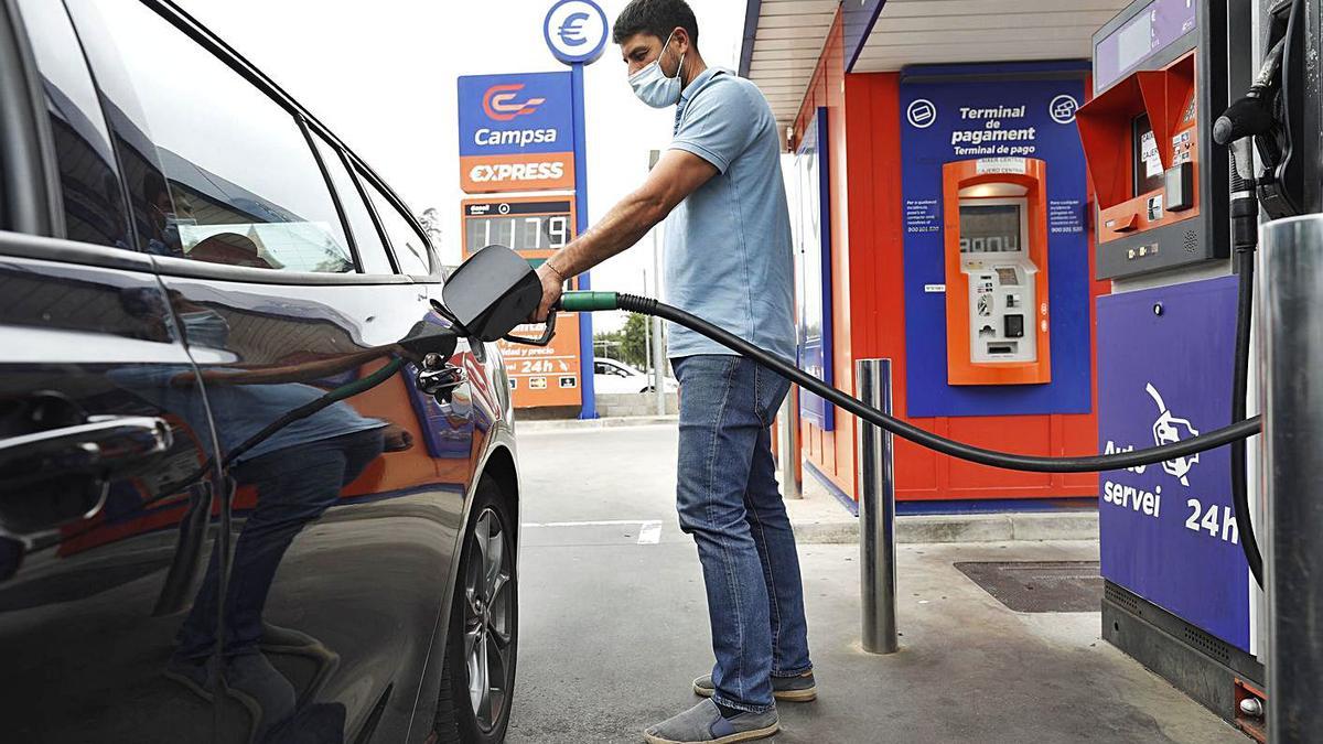 Un usuari omple el dipòsit en una gasolinera de Girona.  | ANIOL RESCLOSA