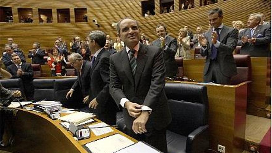 Camps recibe el aplauso de los diputados y consellers del PP.