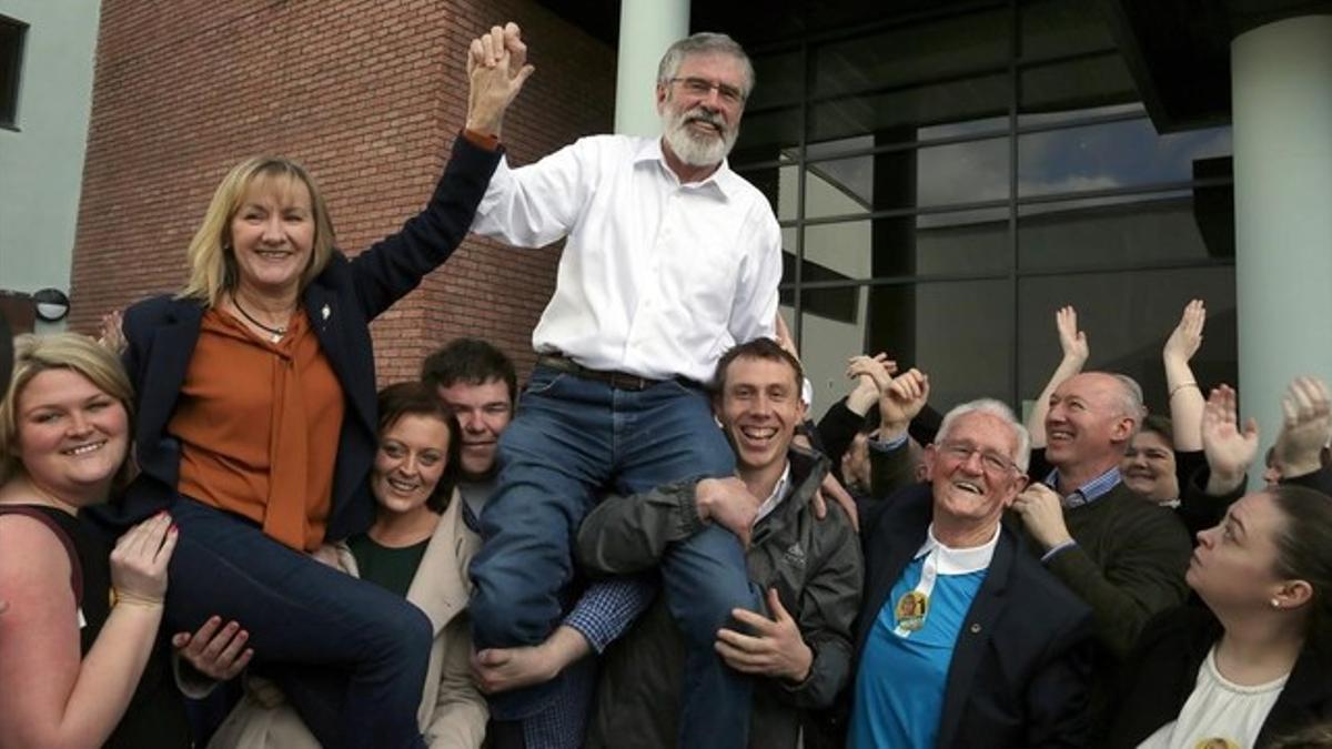 Seguidores del líder del Sinn Féin, Gerry Adams (centro), lo alzan a hombros tras su reelección, en Dundalk (Irlanda), este domingo.