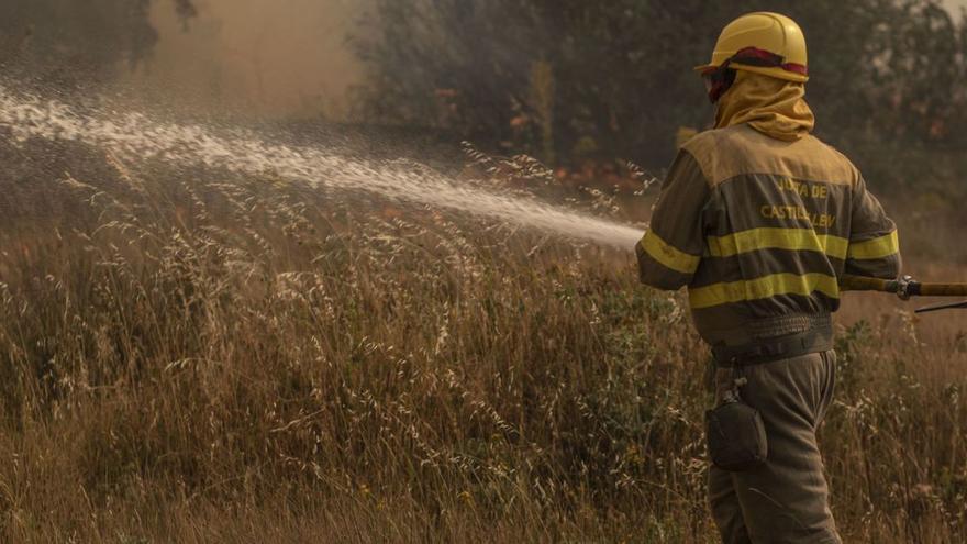 Dos bomberos forestales sostienen una manguera | E.F.