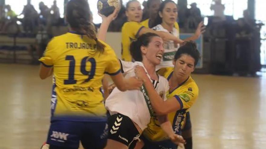 Dos jugadoras del Rocasa frenan a María Flores en una penetración.