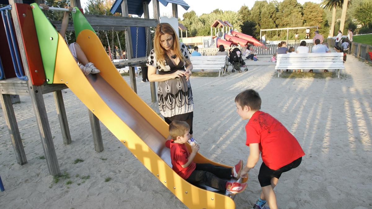 Una mujer embarazada juega con sus hijos en un parque