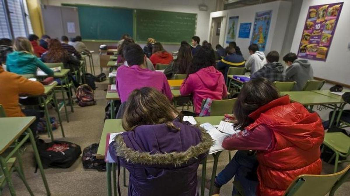 Alumnos en una clase con abrigos.