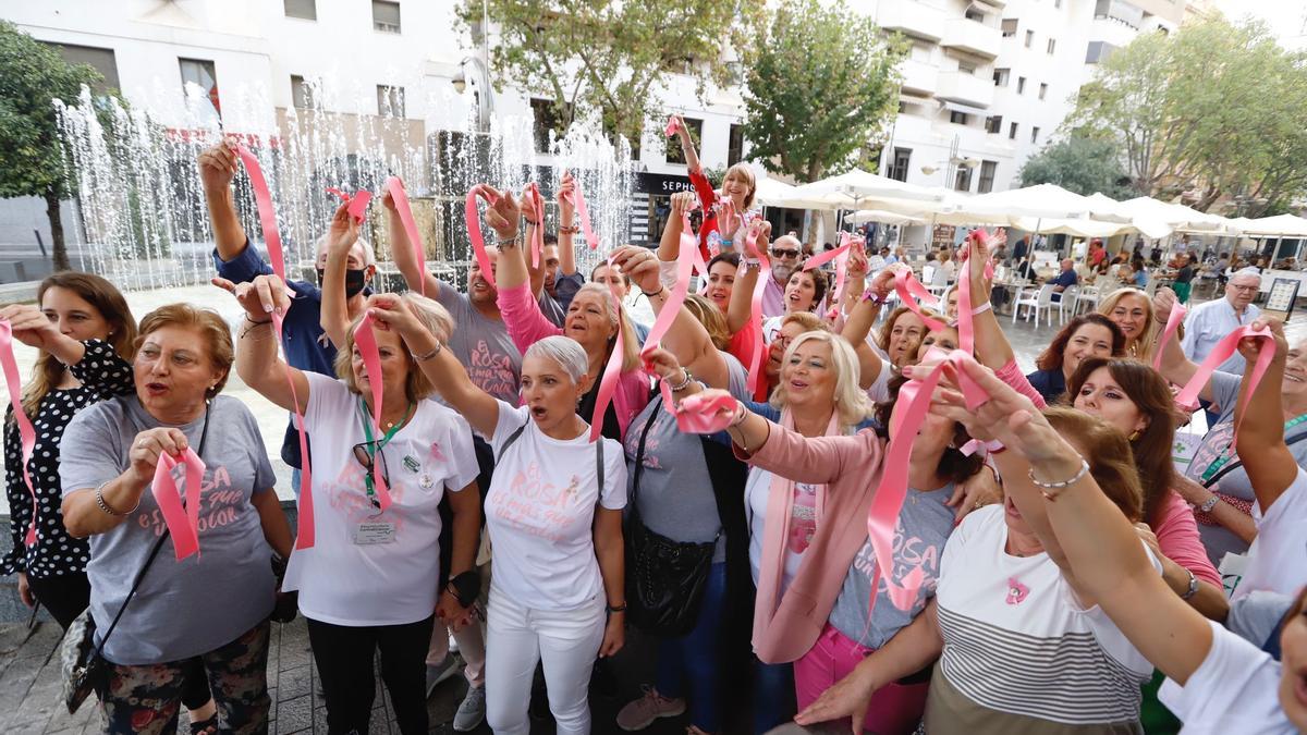 Pacientes y voluntarias de la AECC en Córdoba alzan sus lazos rosa contra la existencia del cáncer de mama.