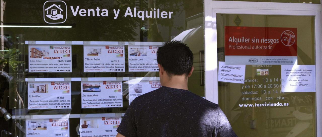 Un hombre ojea los anuncios de una inmobiliaria.