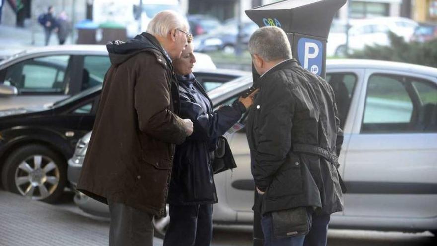 Una vigilante de la ORA informa a usuarios sobre el funcionamiento de los nuevos parquímetros.