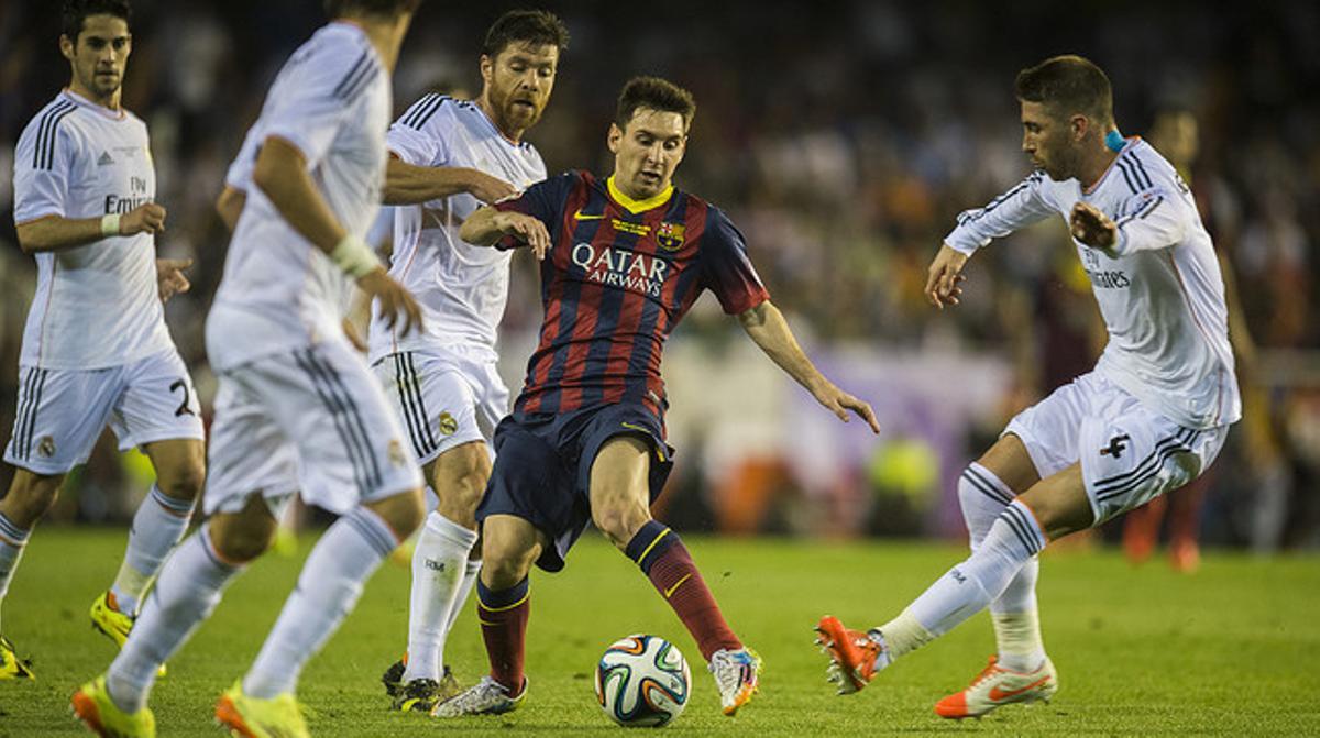 Messi trata de controlar el balón rodeado por Coentrao, Xabi Alonso y Ramos.