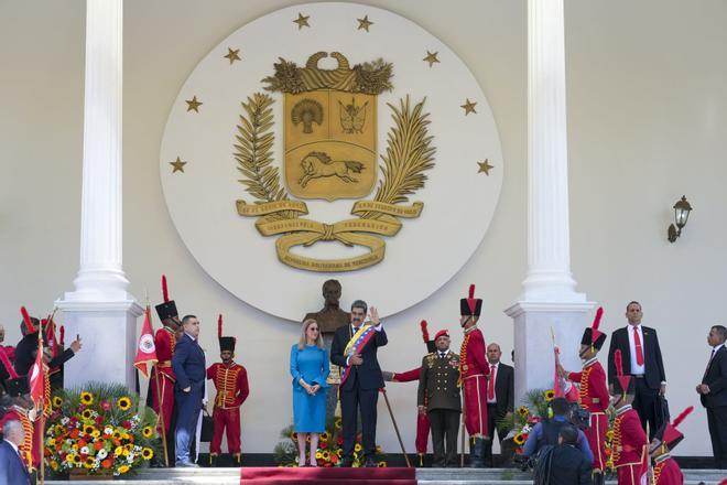 Venezuelan President Nicolas Maduro and his wife Cilia Flores wave after his swearing-in ceremony for a third term in Caracas, Venezuela, Friday, Jan. 10, 2025. (AP Photo/Ariana Cubillos)