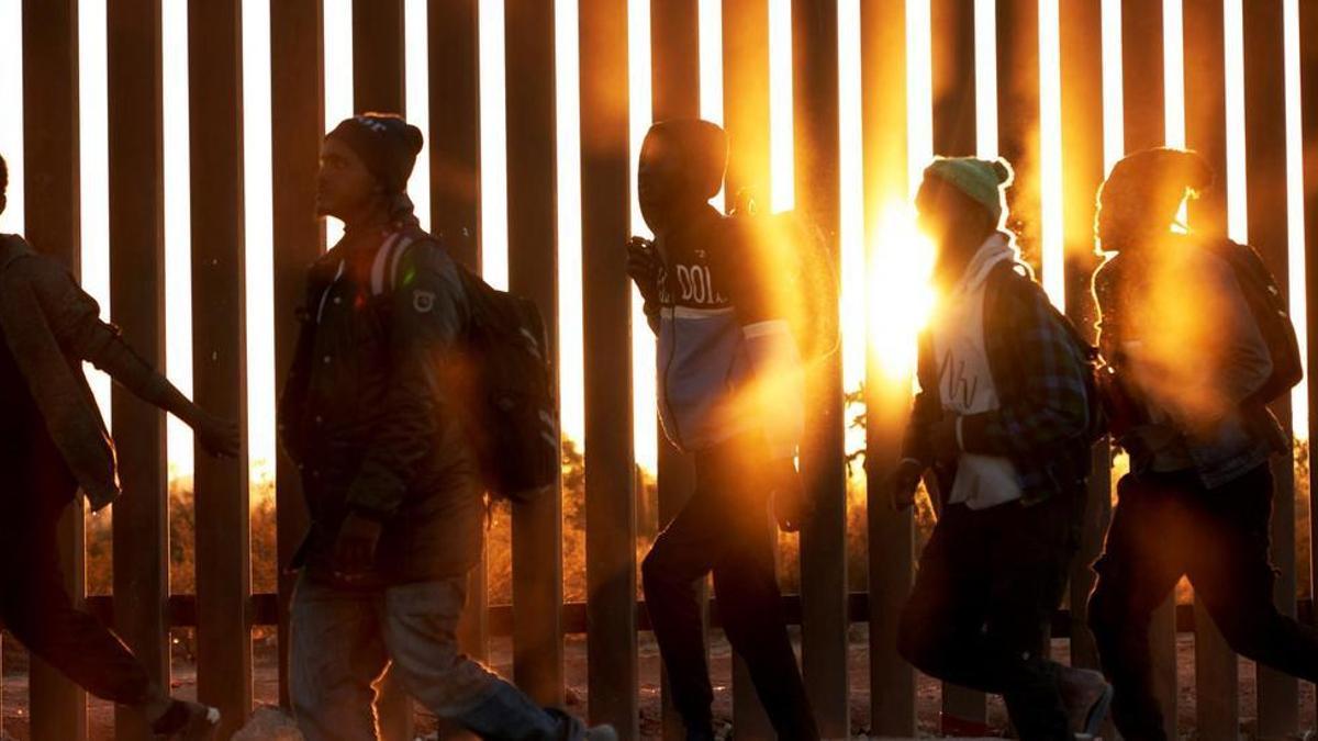 Un grupo de migrantes africanos camina junto al muro de la frontera de México y Estados Unidos, en la localidad de Lukeville.
