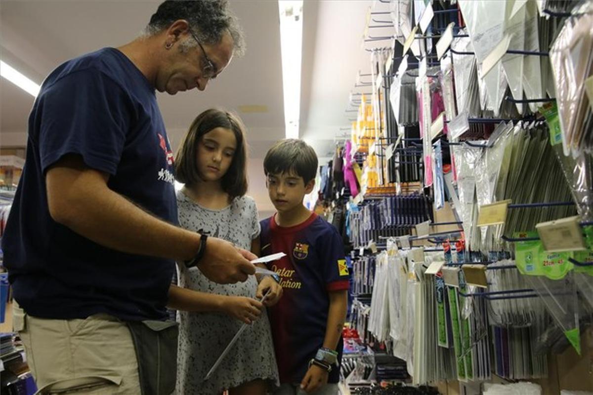 Una família escull el material escolar per al pròxim curs en una botiga de la cooperativa Abacus a Barcelona, dimarts passat.