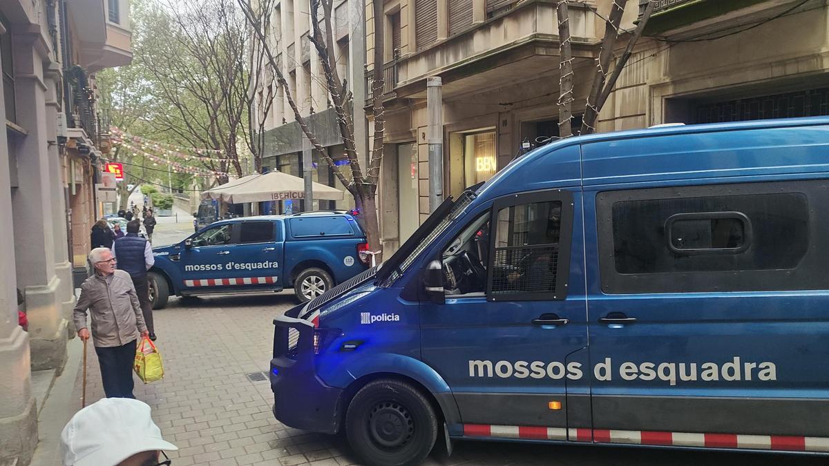 Els vehicles de l'ARRO de Mossos aparcats a banda i banda de la porta de l'edifici on s'ha fet el desnonament