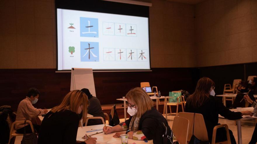 Asistentes al taller de caligrafía en el Etnográfico y un detalle del trabajo. | |  E. F.