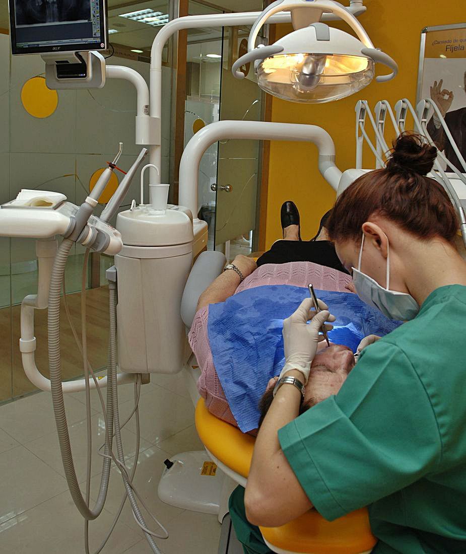 Un odontólogo atiende a un paciente en una clínica dental.   