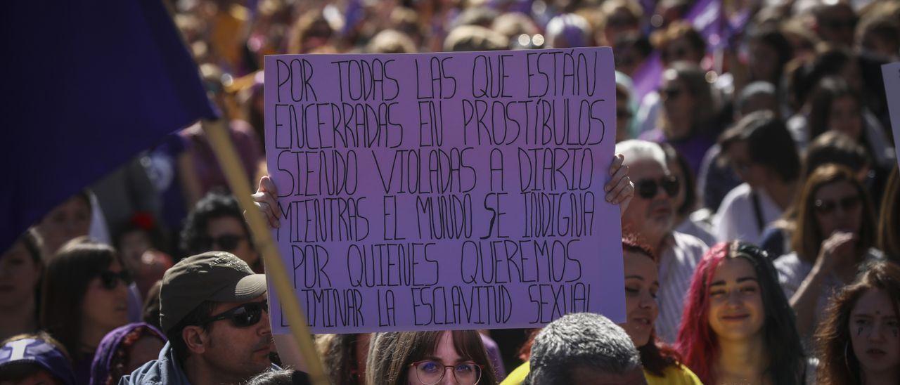 Una mujer sostiene su pancarta con un mensaje de protesta en contra de la prostitución durante la manifestación del 8M de 2020.