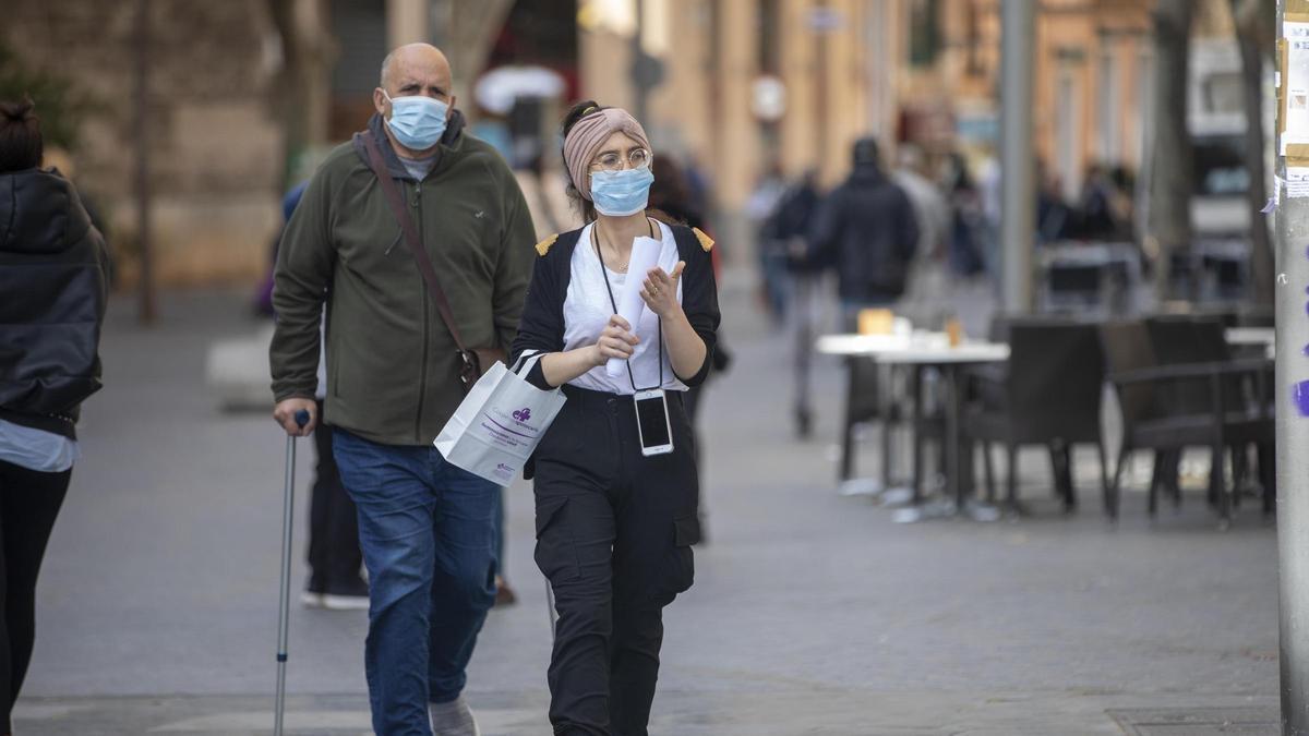 Dos ciudadanos con mascarilla pasean por Palma