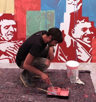 El artista Ayoze Jiménez pintando uno de sus murales.