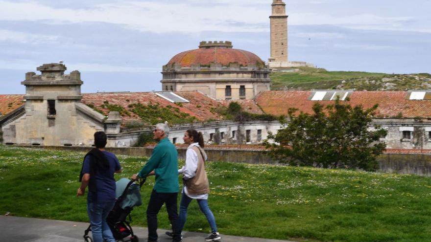 Paseantes en el entorno de la cárcel provincial, con la Torre de Hércules al fondo.   | // VÍCTOR ECHAVE