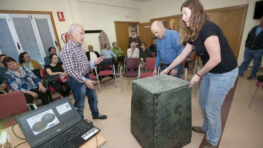 María R. Lafuente arma un compostero, ayer, con los vecinos de Feáns.