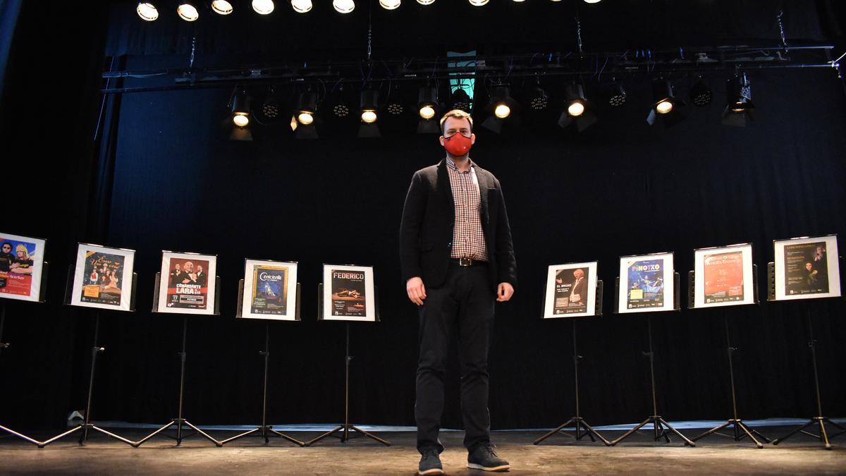 El concejal Fernando Portillo en el escenario del Teatro Cervantes con los carteles de las actividades programadas.