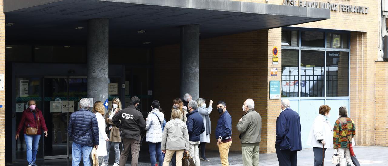 Numerosas personas hacen cola para vacunarse en un centro de salud de Zaragoza.