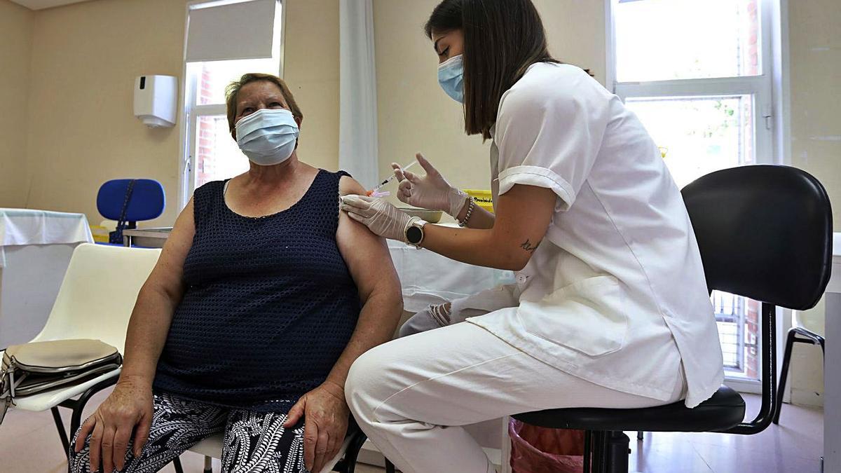 Una enfermera vacuna contra el covid a una mujer, en el centro de salud Bombarda, en Zaragoza.