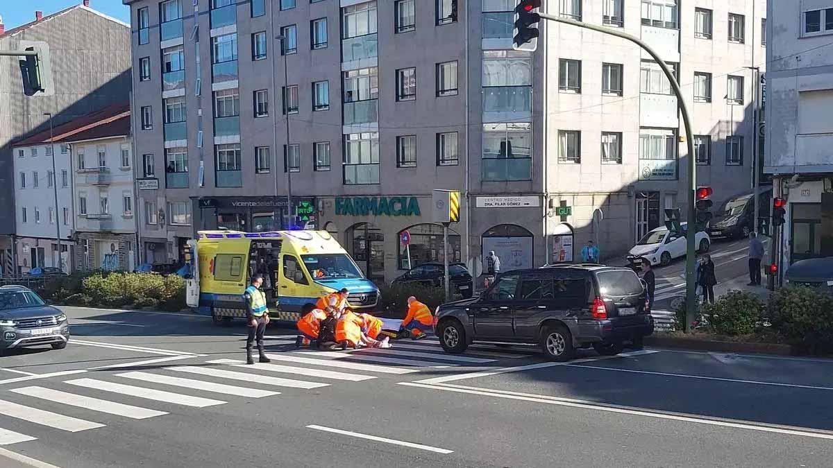 El personal sanitario atiende a la mujer herida de gravedad esta mañana en Santiago.
